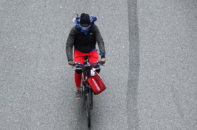 NEW YORK, NEW YORK - MAY 18: A Grubhub delivery person rides a bicycle on 42nd street during the coronavirus pandemic on May 18, 2020 in New York City. COVID-19 has spread to most countries around the world, claiming over 320,000 lives with over 4.8 million infections reported. (Photo by Noam Galai/Getty Images)