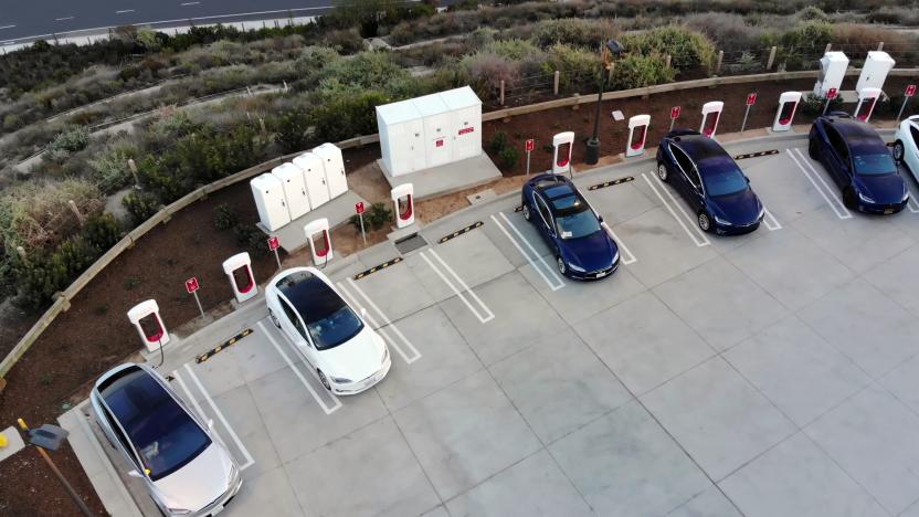 California, USA. - January 13, 2022: View of a white Tesla Model X, a white Tesla Model S and three blue Tesla Model 3s, parked in a parking lot and charging at a Tesla Supercharger electric charging station.