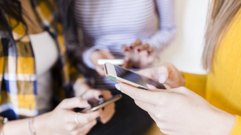 Hands of three women using smartphones