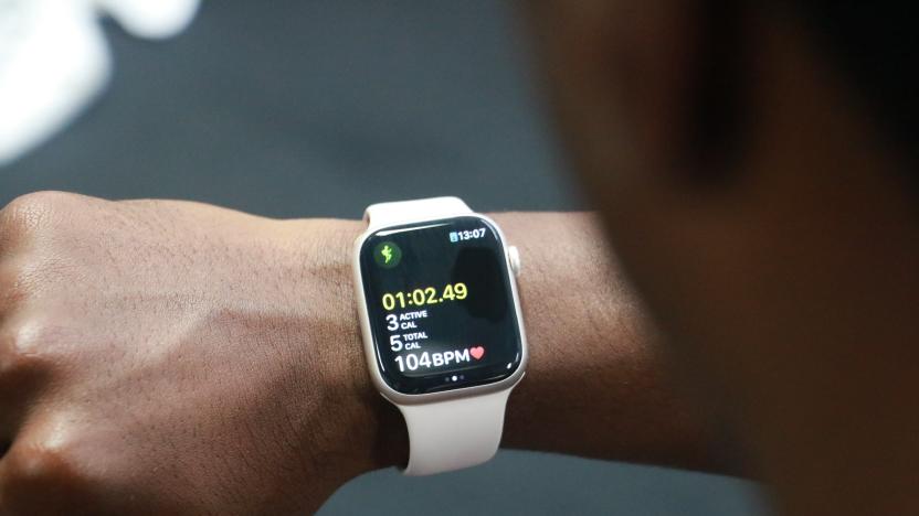 The Apple Watch Series 8 showing a workout tracking screen, on the wrist of a person looking at their watch in a gym.