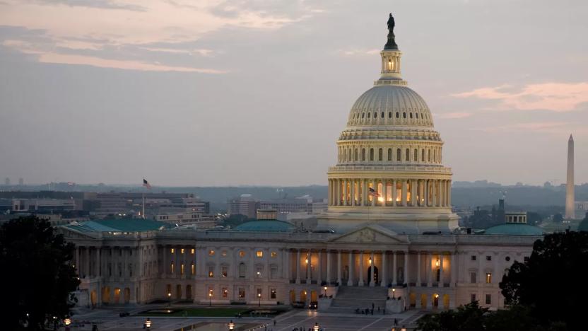 The US Capitol building illuminated against the darkening sky.