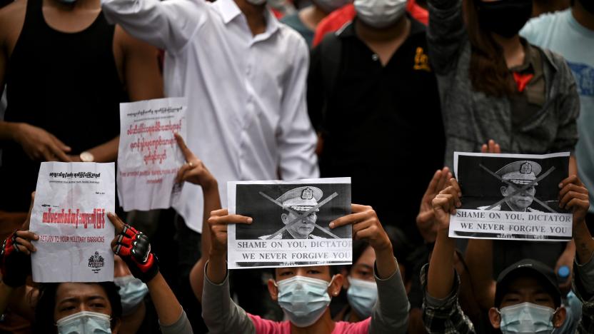 Protesters hold placards during a demonstration against the military coup in Yangon on February 6, 2021. (Photo by Ye Aung Thu / AFP) (Photo by YE AUNG THU/afp/AFP via Getty Images)