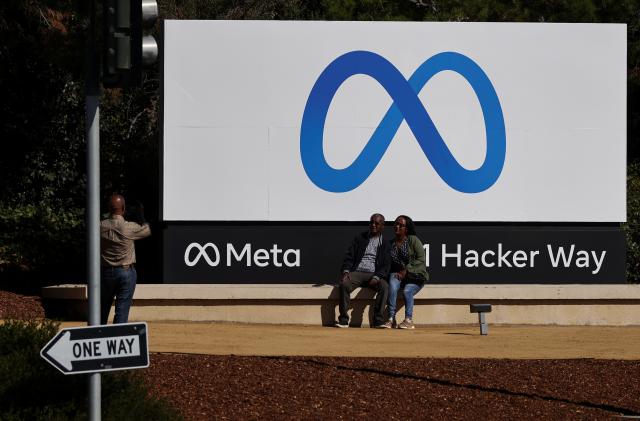 People pose in front of a sign of Meta, the new name for the company formerly known as Facebook, at its headquarters in Menlo Park, California, U.S. October 28, 2021. REUTERS/Carlos Barria