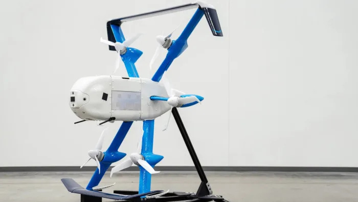 A white and blue drone propped against a stand.