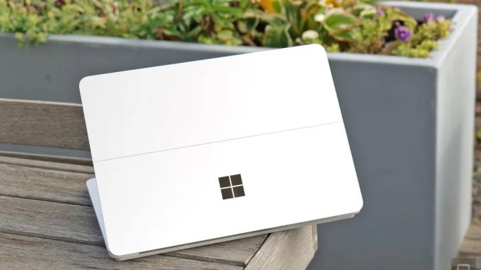 A white device with the Microsoft Windows logo on top of a wooden bench.