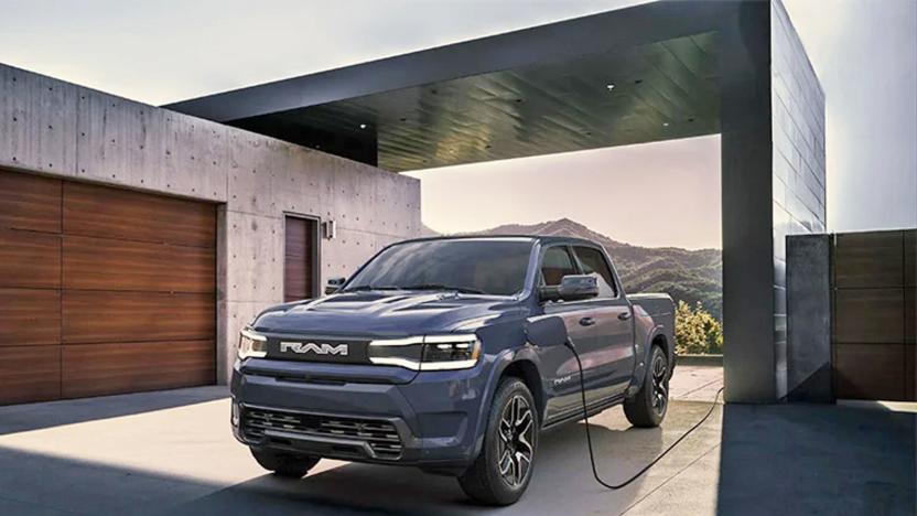 A photo of the production-ready Ram 1500 REV parked in front of a modern minimal house made of concrete.