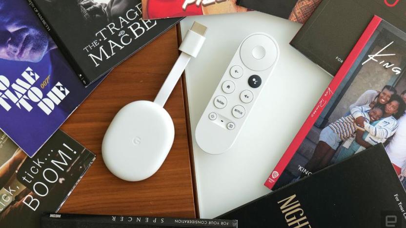 Review photo of the Chromecast with Google TV (HD). The streaming dongle and remote sit on a desk, surrounded by books.