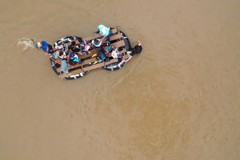 Migrants use an improvised raft to cross the Suchiate river from Tecun Uman in Guatemala to Ciudad Hidalgo in Mexico (AFP Photo/ALFREDO ESTRELLA)