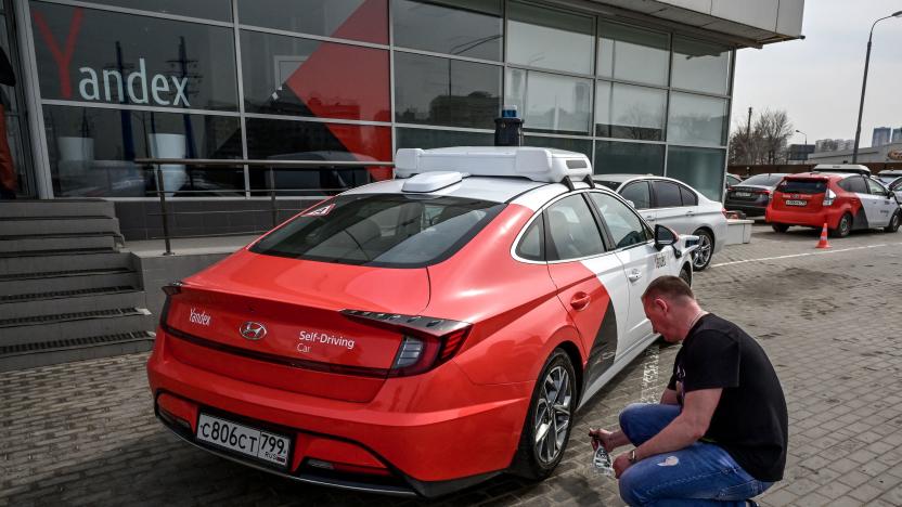 A picture taken on April 15, 2021 shows an engineer cleaning the wheel of a self-driving car, developed by Russian internet giant Yandex, at the company's parking lot in Moscow. (Photo by Yuri KADOBNOV / AFP) (Photo by YURI KADOBNOV/AFP via Getty Images)