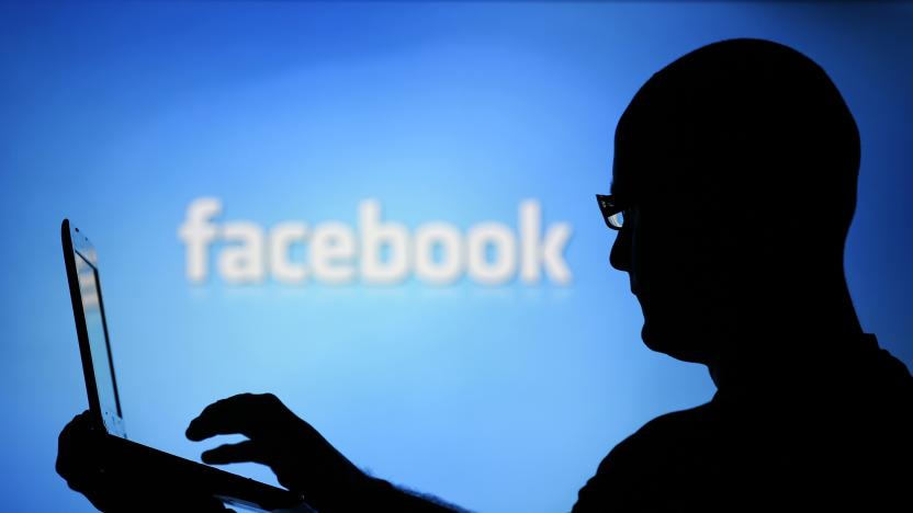 A man is silhouetted against a video screen with an Facebook logo as he poses with an Dell laptop in this photo illustration taken in the central Bosnian town of Zenica, August 14, 2013. REUTERS/Dado Ruvic (BOSNIA AND HERZEGOVINA - Tags: BUSINESS TELECOMS)