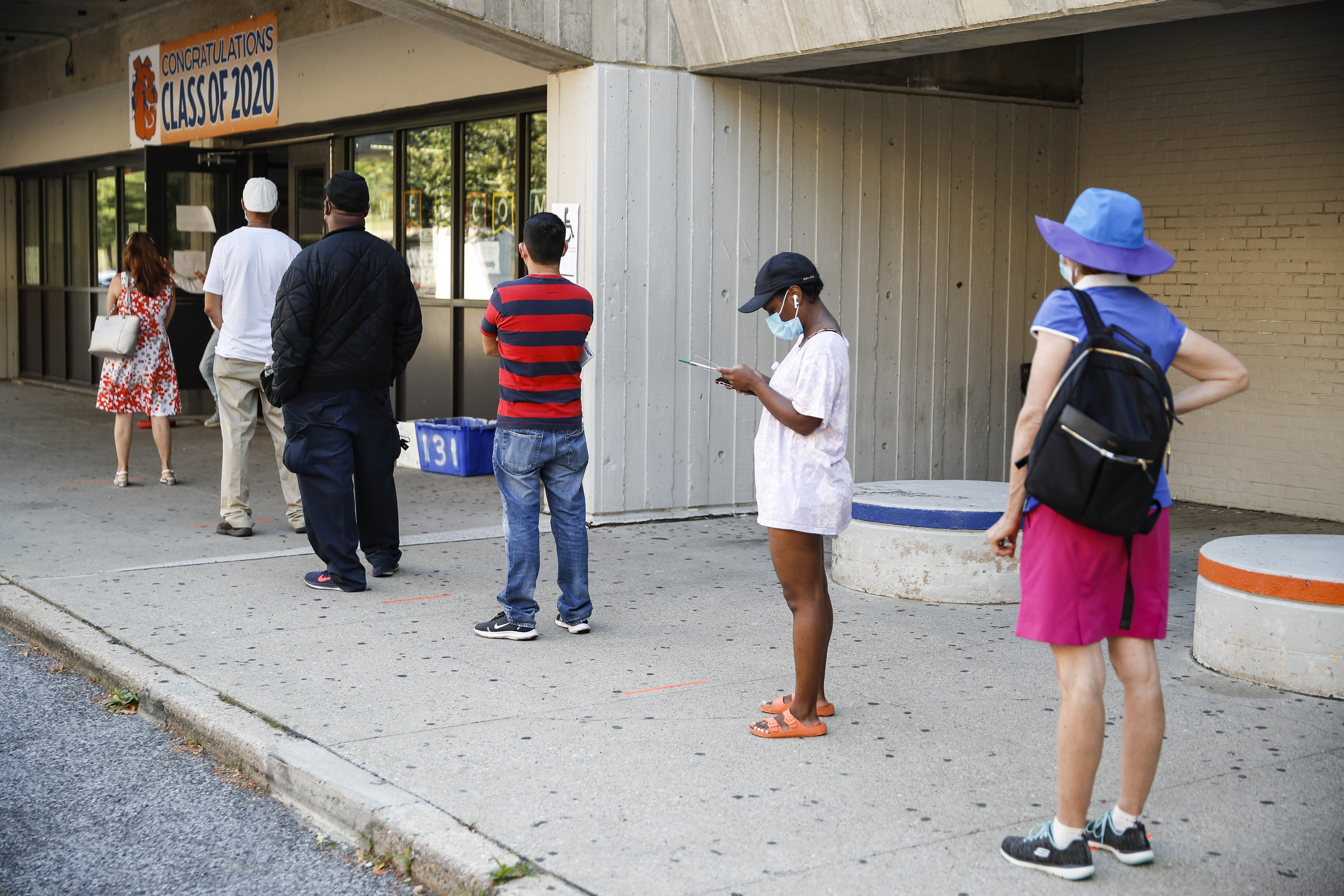 Voters wait in line to cast their ballots in New York's primary election at a polling station inside Yonkers Middle/High School, Tuesday, June 23, 2020, in Yonkers, N.Y. (AP Photo/John Minchillo)