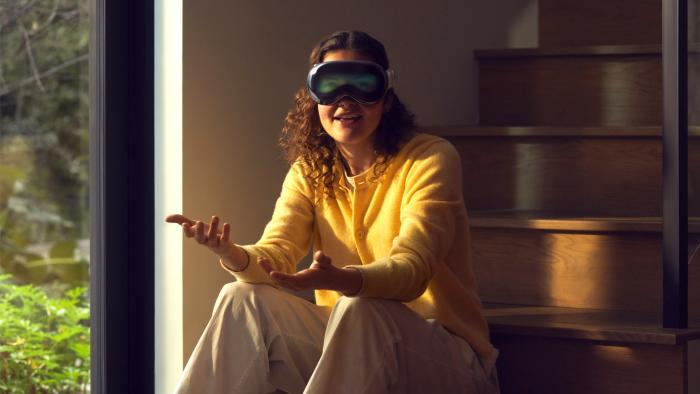 A person is pictured wearing an Apple Vision Pro headset with their eyes projected onto the external display.