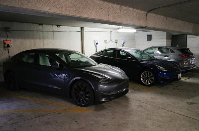 Tesla and Hyundai electric vehicles (EVs) charge at EV charging stations inside a parking garage owned by the City of Baltimore, Maryland, U.S., March 23, 2023. REUTERS/Bing Guan