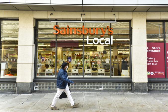 LONDON, UNITED KINGDOM - 2020/11/05: A man wearing a face mask walks past the Sainsburys shop in Holborn, London as Sainsbury's announce they are to cut 3,500 jobs and close 420 Argos stores. (Photo by Dave Rushen/SOPA Images/LightRocket via Getty Images)