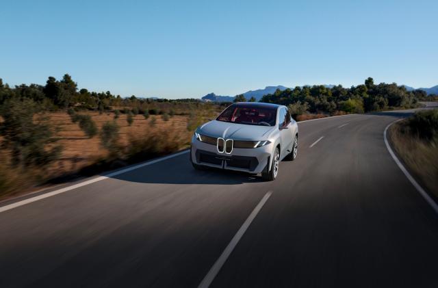 The BMW Vision Neue Klasse X concept electric car on a road that's slightly curving.