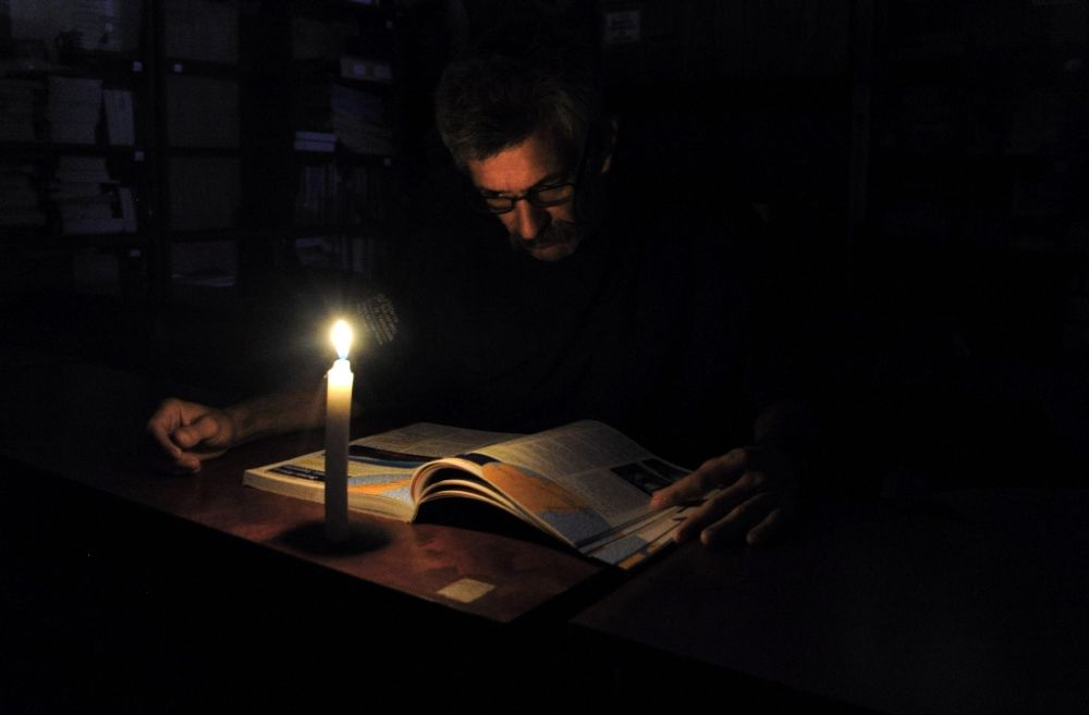 A man reads in candlelight during a power cut in the border state of San Cristobal, Venezuela (AFP Photo/George Castellanos)