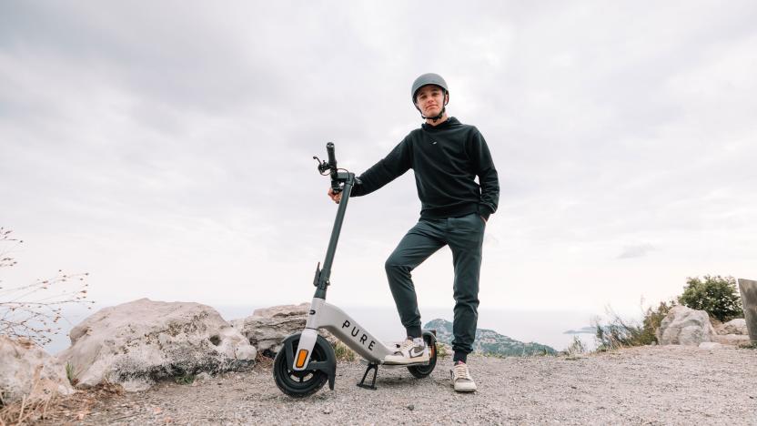 Image of F1 driver Lando Norris stood beside a Pure Electric Advance e-scooter.