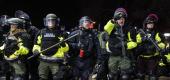 Authorities pursue demonstrators for violating curfew and issue orders to disperse during a protest in Brooklyn Center, Minn. (John Minchillo/AP)