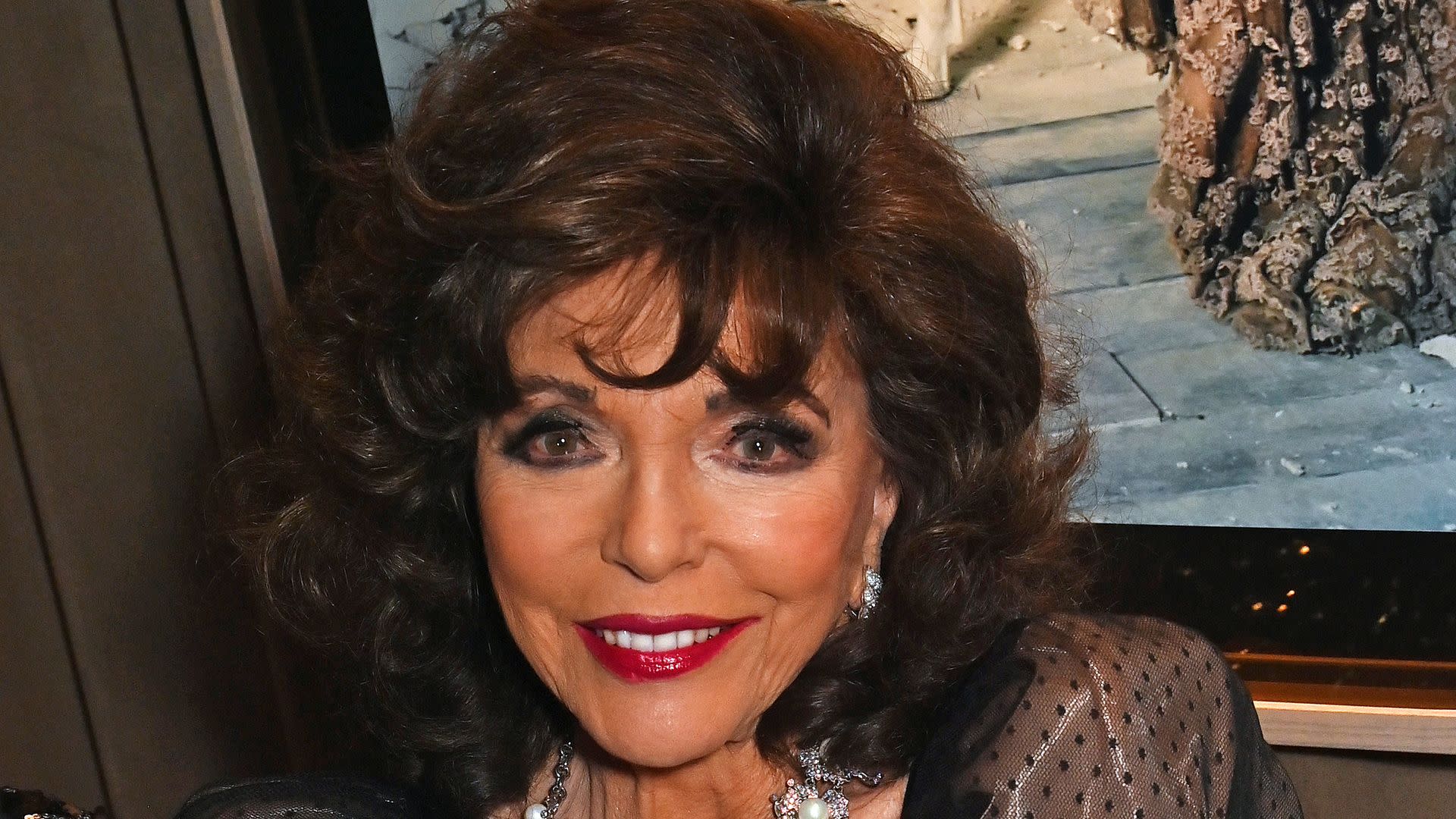 Joan Collins, 91, is ageless in printed midi dress and heels