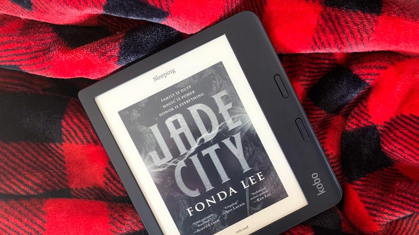 The Kobo Libra 2 e-reader sitting on a black and red checkered blanket.