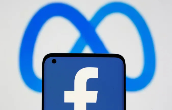 Facebook's new rebrand logo Meta is displayed behind a smartphone with Facebook logo in this illustration picture taken October 28, 2021. REUTERS/Dado Ruvic/Illustration
