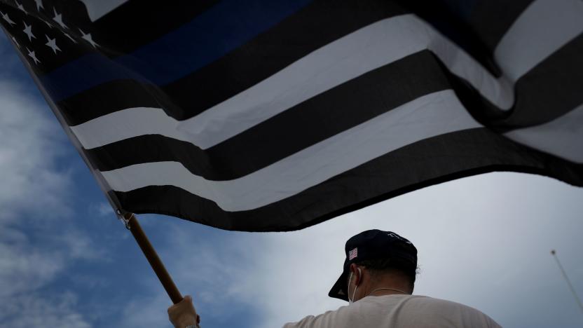 A supporter of US President Donald Trump waves a "Blue Lives Matter" flag as he attends a rally outside the "Latinos for Trump Roundtable" event in Doral, Florida, on September 25, 2020. (Photo by Marco BELLO / AFP) (Photo by MARCO BELLO/AFP via Getty Images)