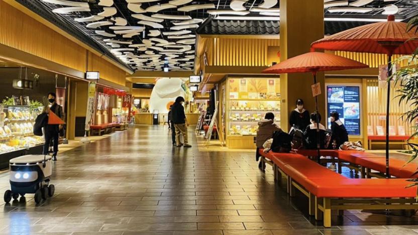 A Cartken robot drives inside an indoor mall.