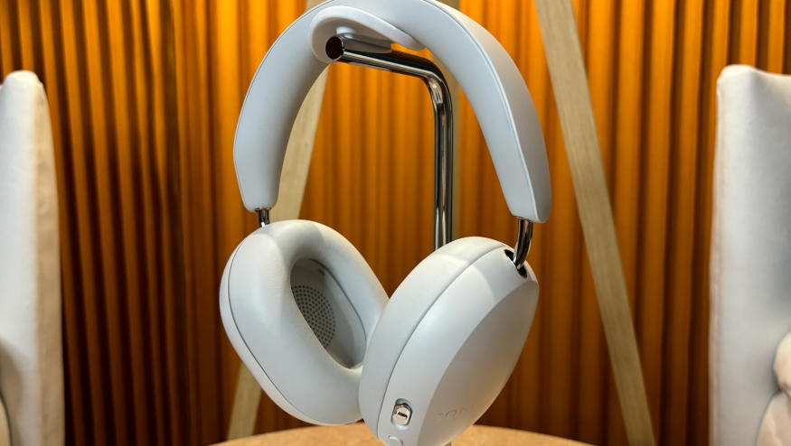 White headphones on stand sitting on a small table. 