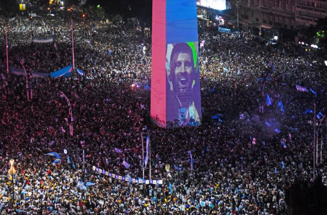 Soccer Football - FIFA World Cup Final Qatar 2022 - Fans in Buenos Aires - Buenos Aires, Argentina - December 18, 2022  Argentina fans celebrate winning the World Cup at the Obelisk with an image of Lionel Messi.