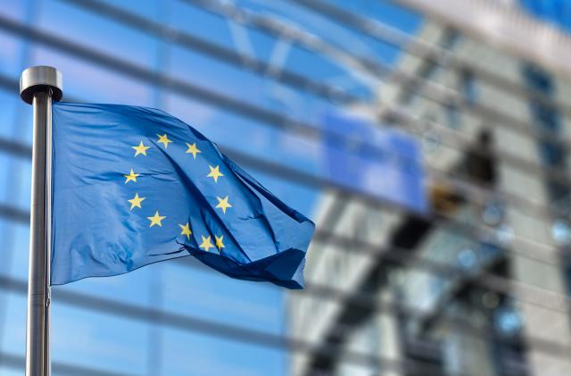 European Union flags in front of the blurred European Parliament in Brussels, Belgium