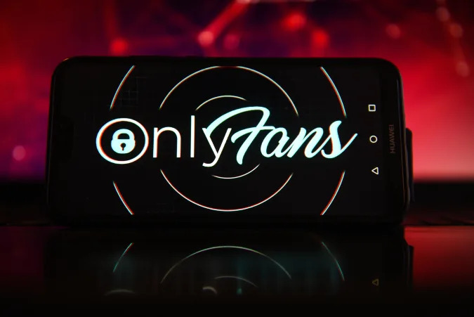 POLAND - 2022/01/03: In this photo illustration the OnlyFans logo seen displayed on a smartphone with stock market percentages in the background. (Photo Illustration by Omar Marques/SOPA Images/LightRocket via Getty Images)