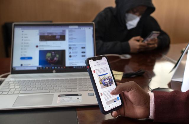 Ian James Mwai (R), 23, browses social media platforms on his mobile phone with a member of his outfit of social media influencers at an office in Thika town, central Kenya on April 26, 2022. - Ian James Mwai is in the vanguard of the growing ranks of influencers feverishly punching keyboards and hoping to tilt the outcome of the country's high-stakes elections, which are barely 100 days away.
The rising dominance of apps like Twitter and Facebook has opened up a new front in Kenyan politics, with candidates desperate to draw the attention of the country's 12 million social media users. (Photo by Tony KARUMBA / AFP) (Photo by TONY KARUMBA/AFP via Getty Images)