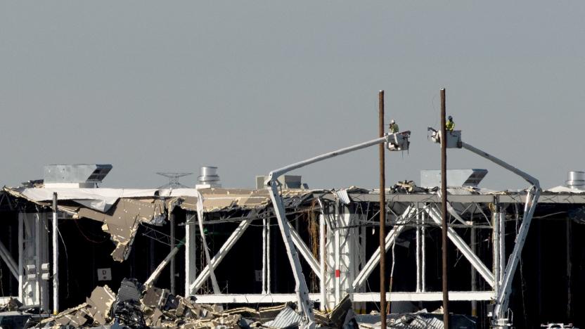 Amazon crew on lifts document the damage from the tornado that hit an Amazon distribution centre where the roof collapsed in Edwardsville, Illinois, U.S. December 13, 2021.  REUTERS/Lawrence Bryant