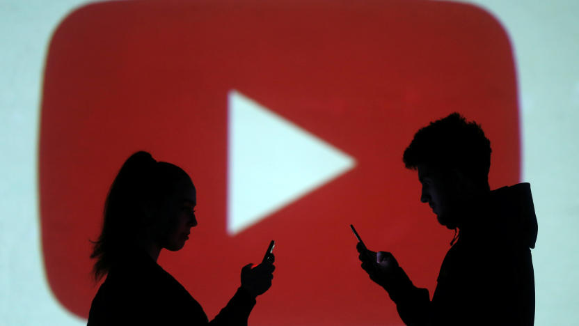 Silhouettes of mobile users are seen next to a screen projection of Youtube logo in this picture illustration taken March 28, 2018.  REUTERS/Dado Ruvic/Illustration