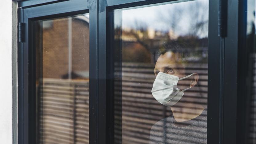 Man with mask looking out of window