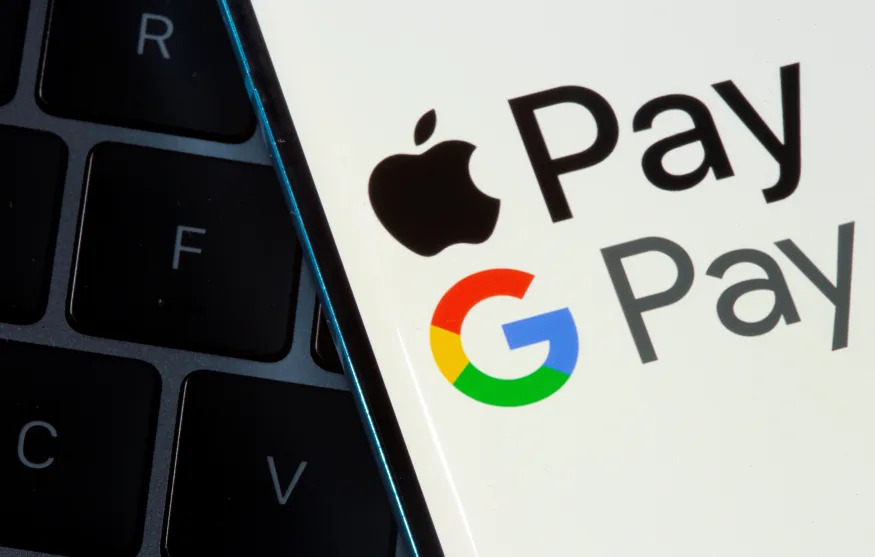 A smartphone with Apple Pay and Google Pay logos is placed on a laptop in this illustration taken on July 14, 2021. REUTERS/Dado Ruvic/Illustration