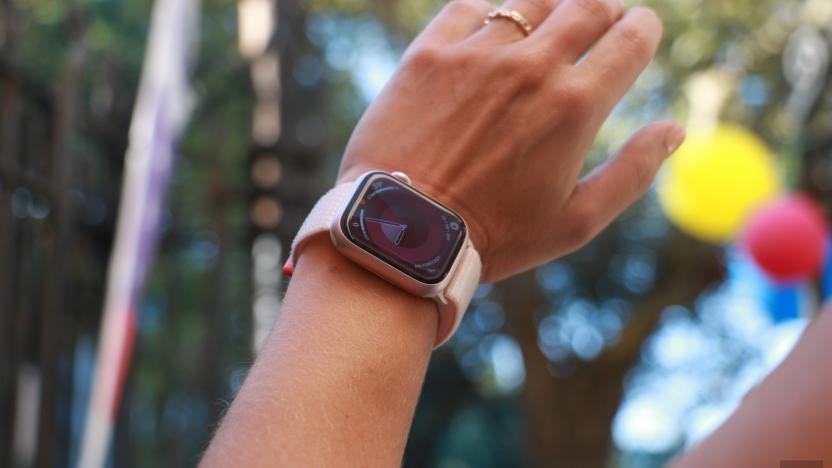 The Apple Watch Series 9 on a wrist in mid-air, with some balloons in the blurred background.