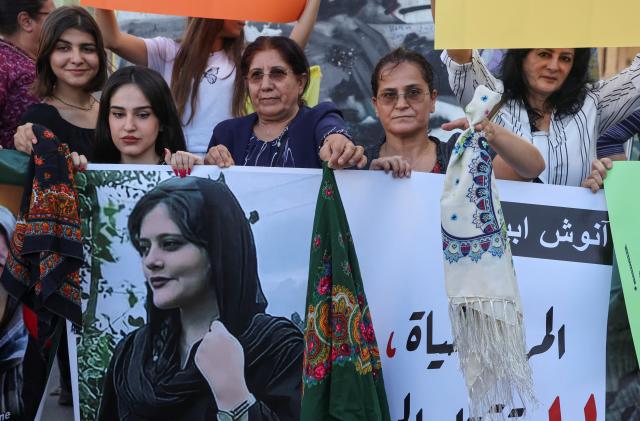 Women hold a picture of Mahsa Amini during a sit-in following her death, at Martyrs' Square in Beirut, Lebanon September 21, 2022. REUTERS/Mohamed Azakir