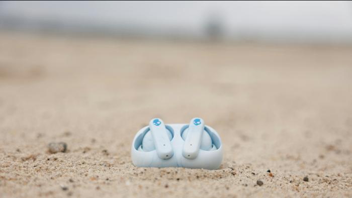 An image of earbuds in the sand. 