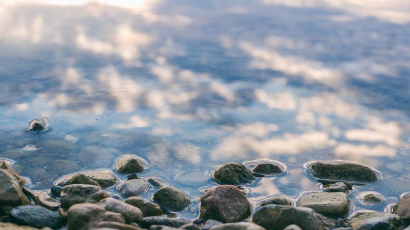 Pebbles at the edge of some water.