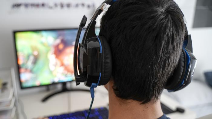 Boy with headphones playing on his computer