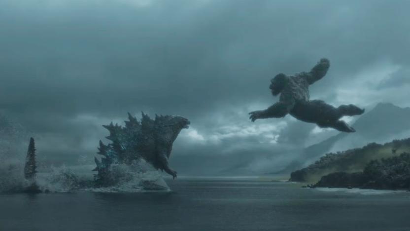 Godzilla and King Kong approach each other for battle: Godzilla wades through water as King Kong leaps at him from the coast.