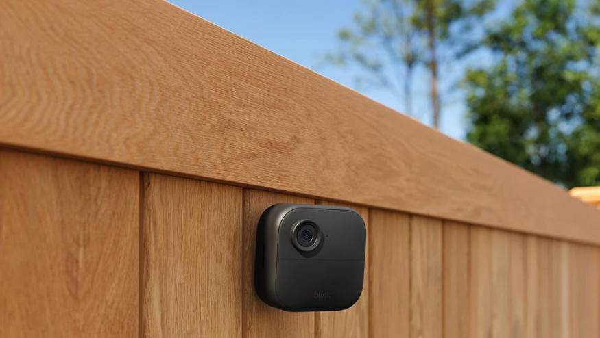 The Blink Outdoor 4 camera is mounted to a fence, keeping a watchful eye on the back yard. 