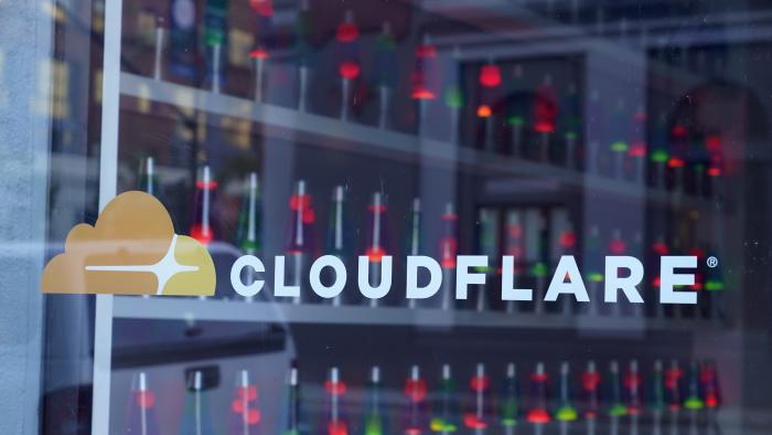 Lava lamps are seen through a lobby window at the headquarters of Cloudflare in San Francisco, Wednesday, Aug. 31, 2022. Citing “imminent danger,” Cloudflare has dropped the notorious stalking and harassment site Kiwi Farms from its internet security services. (AP Photo/Eric Risberg)