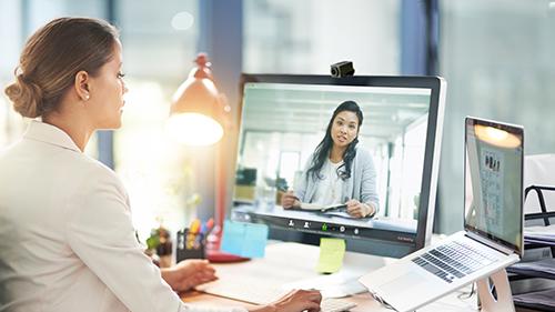 Shot of two colleagues video chatting with each other on a computer at work