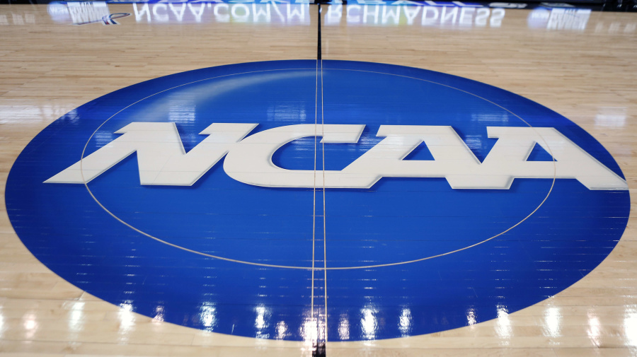 Associated Press - FILE - The NCAA logo is displayed at center court at The Consol Energy Center in Pittsburgh, March 18, 2015. Ten players from North Carolina State's 1983 national champion basketball team have sued the NCAA and the Collegiate Licensing Company seeking compensation for unauthorized use of their name, image and likeness. The players filed suit in Wake County Superior Court on Monday, June 10, 2024, requesting a jury trial and “reasonable compensation.” (AP Photo/Keith Srakocic, File)