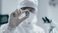 Female engineer inspecting wafer chip in laboratory