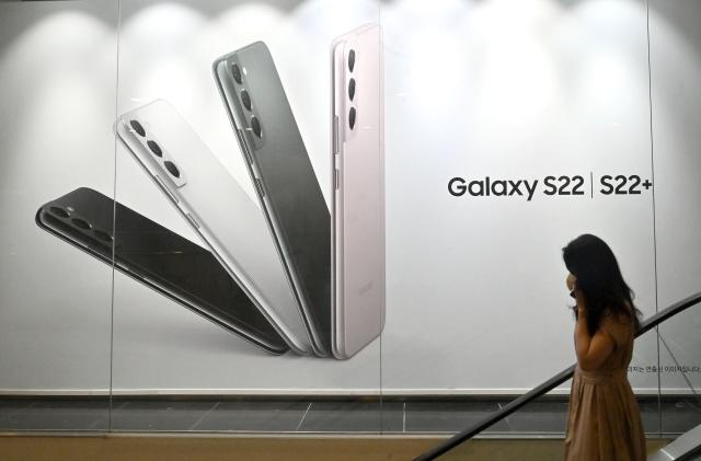 A woman walks past an advertisement for the Samsung Galaxy S22 smartphone at the company's Seocho building in Seoul on July 7, 2022. (Photo by Jung Yeon-je / AFP) (Photo by JUNG YEON-JE/AFP via Getty Images)