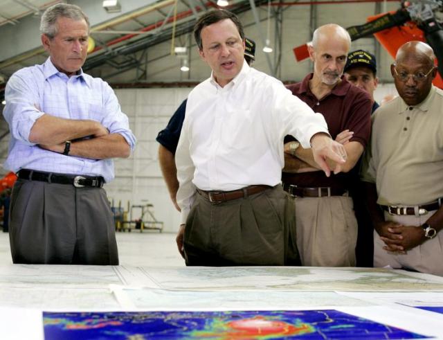 President George W. Bush (L) and Homeland Security Secretary Michael Chertoff (2nd R) get a briefing from Federal Emergency Management Agency (FEMA) chief Michael Brown (C) upon their arrival 02 September, 2005, at a US Coast Guard Base in Mobile, Alabama, before touring the devastation left by Hurricane Katrina. (Photo: Jim Watson/AFP/Getty Images)
