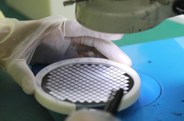 NANTONG, CHINA - MARCH 17: Employees work on the production line of silicon wafer at a workshop of Jiejie Semiconductor Co., Ltd on March 17, 2021 in Nantong, Jiangsu Province of China. (Photo by Xu Congjun/VCG via Getty Images)